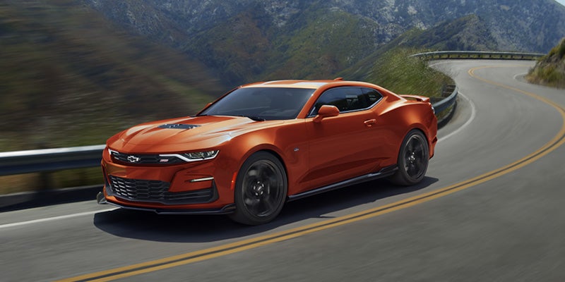Photo of a orange 2024 Chevrolet Camaro driving on the road