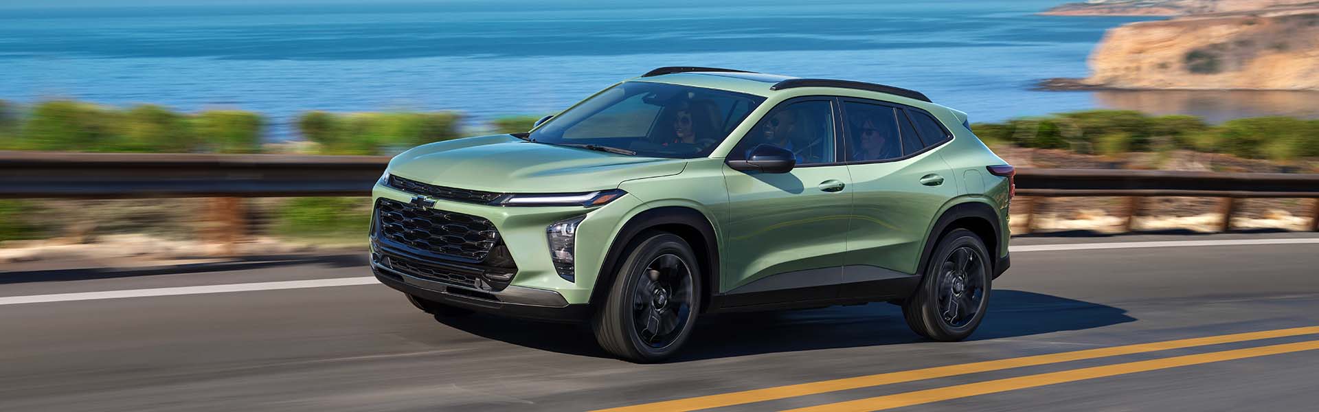 Photo of a 2024 Chevrolet Trax driving on the road by a body of water